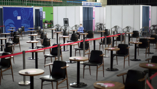 10일 경남 김해시 문화체육관에 마련된 백신접종센터에서 코로나19 백신을 접종한 시민이 이상 반응 여부 확인을 위해 의자에 앉아 있다.  연합뉴스